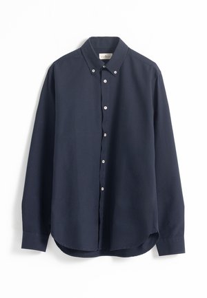 Camisa azul marino de botones, con mangas largas, dobladillo redondeado y botones blancos. Tela suave con cuello y un pequeño logo en el pecho.