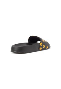 Svart slidesandal med en låg, tjock sula och ett mönster av gula gummiaan som pryder ovansidan, med en öppen design och slät textur.