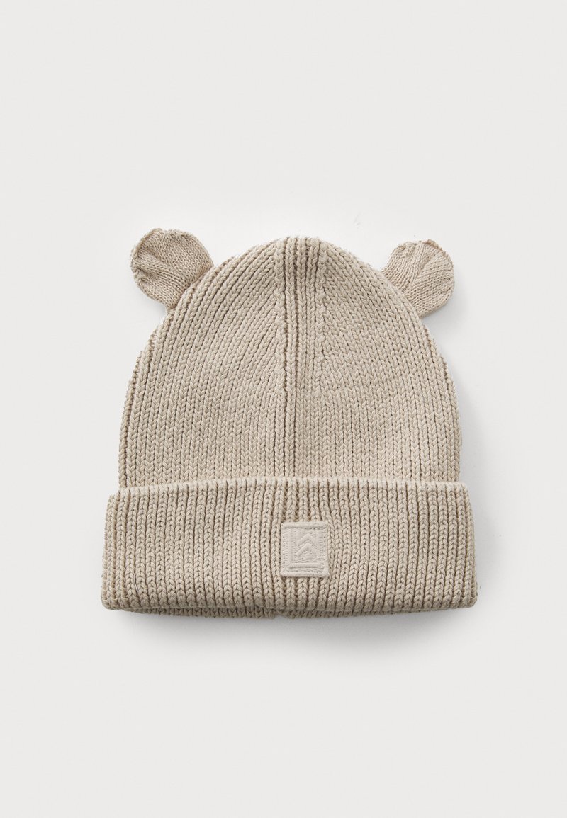 Bouton beige tricoté avec des oreilles d'ours, texture côtelée et revers replié. Présente un patch de marque monochromatique en forme carré sur le devant.