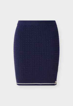 Marineblå strikket skjørt med et teksturert kabelmønster. Har ribbet midjebånd og en hvit stripe langs nederkanten.