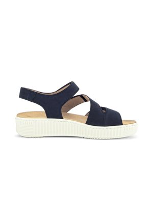 Navy blue open-toe sandal with adjustable heel strap and white textured platform sole, side view.