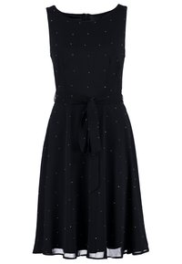 Musta hihaton mekko, jossa istuva yläosa ja levenevä helma. Mekossa on pieniä kiiltäviä yksityiskohtia ja solmittava vyötärönauha korostusta varten.