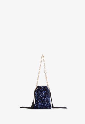 Marineblauwe sequins tas met een gouden schouderband en zwarte kwast accenten. Rechthoekige vorm, gestructureerd oppervlak en een trekkoordsluiting.