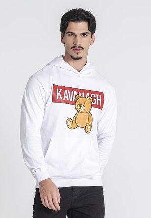 Sudadera blanca con un gráfico frontal que presenta un oso de dibujos animados y el texto "KAVANAGH" en rojo. Tejido suave, corte relajado y bolsillo tipo canguro.
