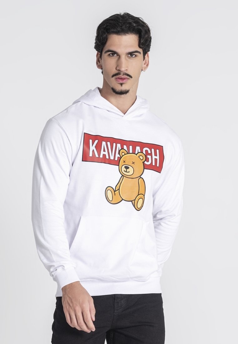 Sudadera blanca con un gráfico frontal que presenta un oso de dibujos animados y el texto "KAVANAGH" en rojo. Tejido suave, corte relajado y bolsillo tipo canguro.
