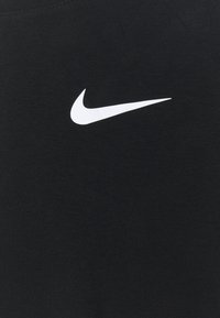 Black cotton fabric with a textured finish, featuring a prominent white Nike swoosh logo positioned centrally.
