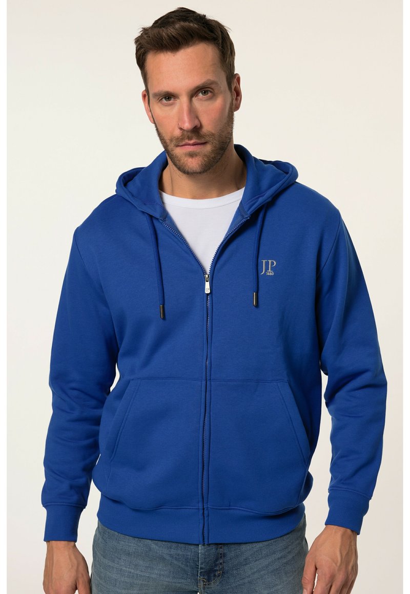 Felpa con zip blu realizzata in tessuto misto cotone. Presenta un cappuccio con cordini, tasche frontali e un piccolo logo sul petto.