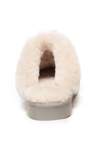 Fluffy slip-on slippers in cream color. Soft faux fur material with a rounded opening and cushioned insole, featuring a sturdy light gray sole.