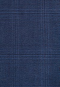Tissu bleu foncé avec un motif tissé texturé présentant des lignes verticales et horizontales formant un motif à carreaux subtil.