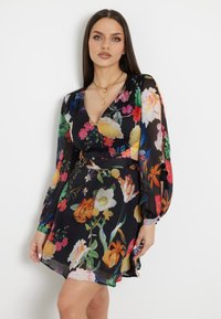 Rochie neagră cu flori, cu un decolteu adânc în V, mâneci lungi și voluminoase, și modele colorate de flori. Material ușor, cu un design fluid.
