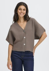 Brun kortärmad kort cardigan i en strukturerad stickning, med en djup V-ringning och fem silverknappar fram.