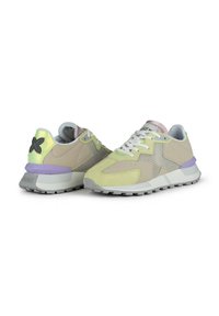 Zapatillas deportivas elegantes que combinan cuero beige y malla, acentos en amarillo claro, un talón morado y una suela texturizada.