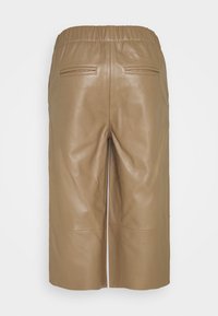 Taanse leren culottes met een elastische tailleband, twee achterzakken, een gladde textuur en een knielange snit, met minimale stikseldetails.