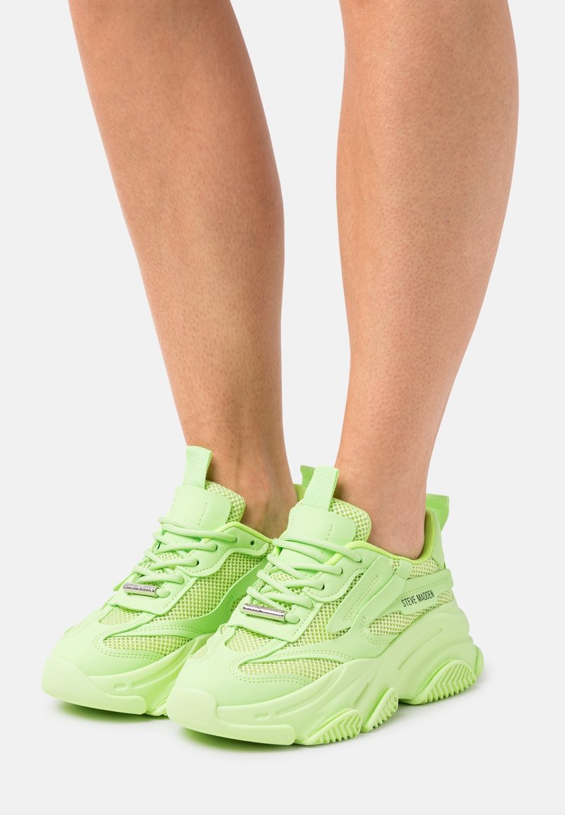 Neonowe zielone sneakersy z teksturowaną siateczkową cholewką, wzmocnionym czubkiem i chunky podeszwą. Zawierają sznurowanie oraz szczegóły z logo na boku.