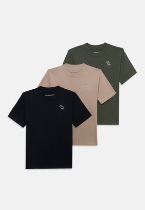 Três t-shirts de manga curta: uma preta, uma bege e uma verde-escura em tecido de algodão, cada uma com um pequeno logótipo de animal bordado no peito.