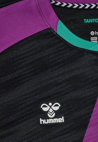 Sort sports jersey med lilla og teal accenter, udstyret med et struktureret stof, rund halsåbning, og "hummel" logo på fronten.