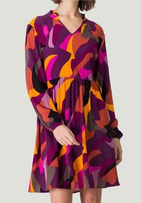 Robe multicolore avec un décolleté en V, des manches longues avec des poignets élastiques et une taille froncée. Le tissu a une texture lisse avec des motifs abstraits en violet, orange et rose.