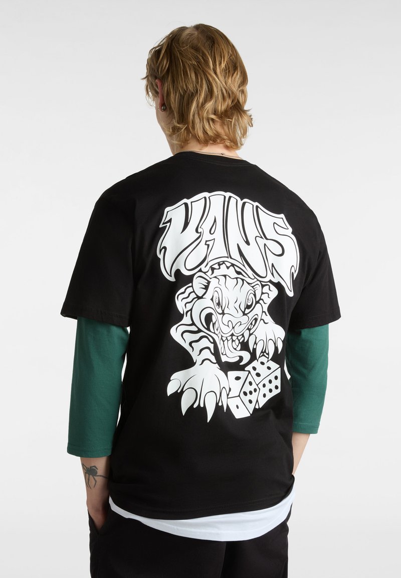 Camiseta negra con un gran gráfico blanco de un tigre y dados en la parte posterior. Manga corta, material de algodón y diseño de cuello redondo.