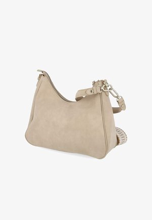 Sac à bandoulière en cuir beige avec ferrures argentées, fermeture éclair et bandoulière amovible, posé sur une surface blanche avec un objet tissé partiellement visible.