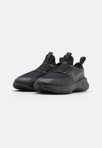 Schwarze Sportschuhe mit einem atmungsaktiven Mesh-Obermaterial, Gummisohle und Zuglaschen. Sie verfügen über eine glatte, matte Oberfläche mit durchbrochener Akzentuierung.