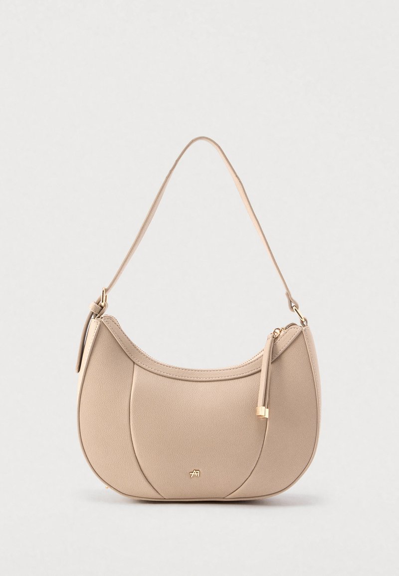 Borsa a tracolla in pelle beige a forma di mezzaluna, con chiusura superiore con cerniera e tracolla removibile. Presenta dettagli in metallo color oro e accenti cuciti.