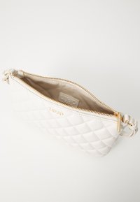 Borsa a tracolla bianca trapuntata con zip color oro, caratterizzata da una superficie testurizzata e manico intrecciato. L'interno ha una fodera liscia e etichetta del marchio.