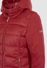 Giacca imbottita rossa con cappuccio, chiusura con zip frontale e tasche laterali. Presenta una texture liscia e una toppa con logo sulla manica.