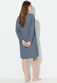 Vestido de lunares azules y blancos con mangas largas, hasta la rodilla, con aberturas laterales, hecho de una tela suave, con un corte holgado y escote redondo.