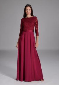 Burgundy klänning med spetsliv med trekvartsärmar, en slät kjol och ett satinmidjeband för en strukturerad look.