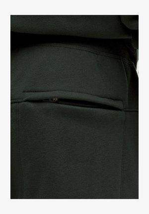 Tessuto di felpa verde scuro con tasca con zip, superficie liscia e vestibilità comoda, con dettagli di cucitura lungo le cuciture.