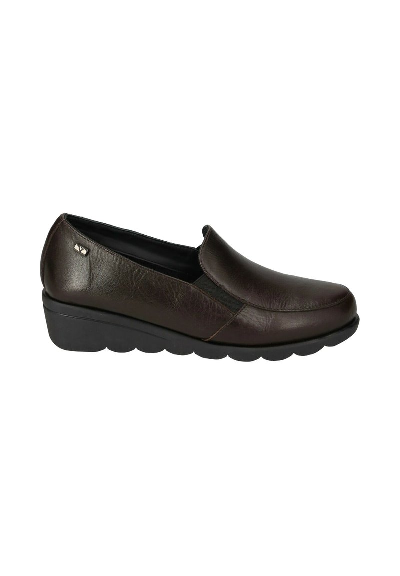 Scarpa slip-on in pelle marrone con punta arrotondata, dettagli elastici ai lati e superficie texture. Presenta una suola a zeppa nera bassa.