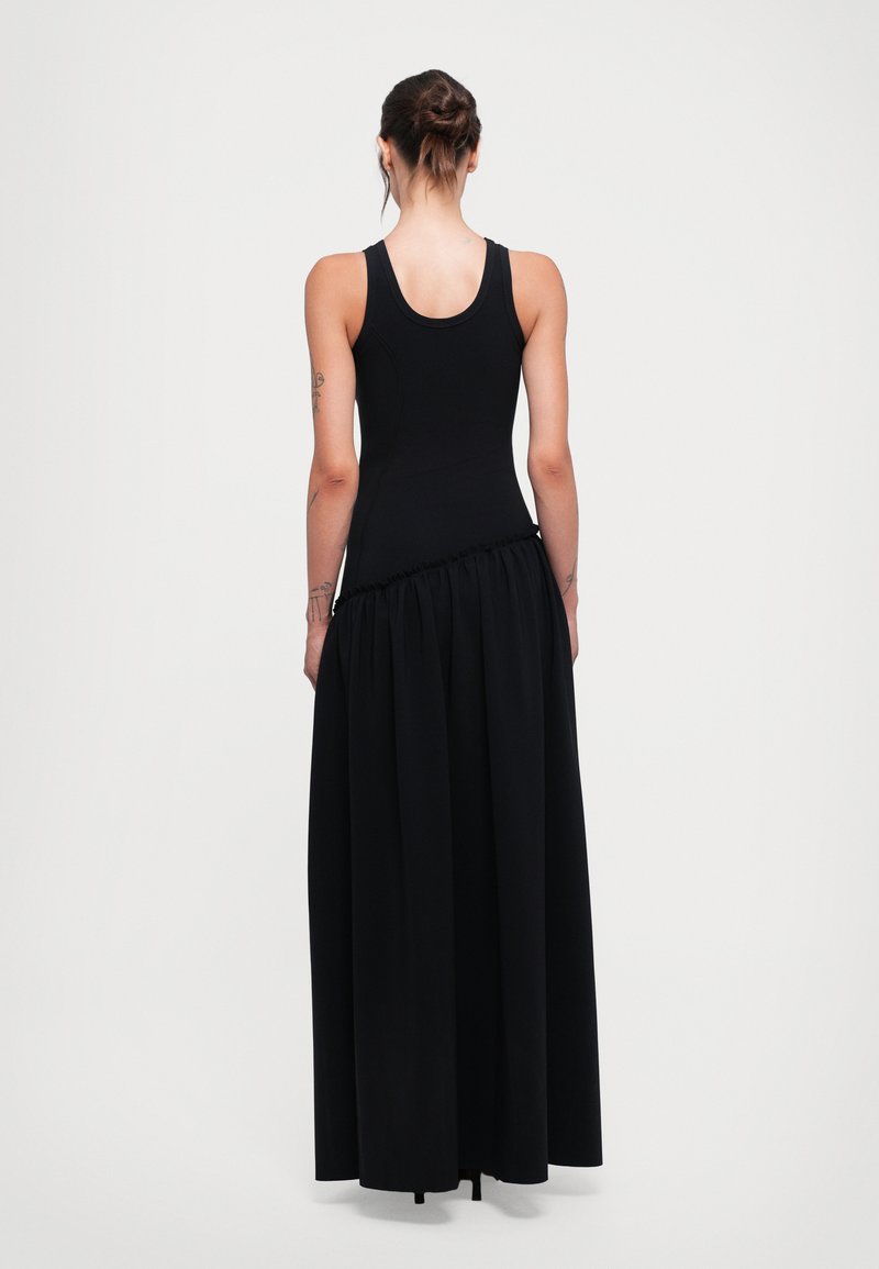 Black maxi dress featuring a fitted tank top bodice with a gathered, flowing skirt. Smooth texture, minimalist design, rear view shown.
