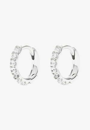 Paire de boucles d'oreilles créoles en argent, chacune ornée de sept petites pierres précieuses rondes et transparentes sur le côté avant.