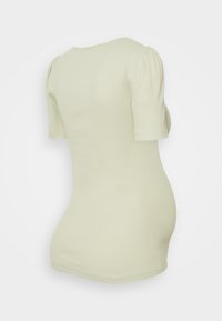 T-shirt ribbed verde-claro com mangas curtas bufantes, gola redonda e corte ajustado. O material parece suave e elástico.