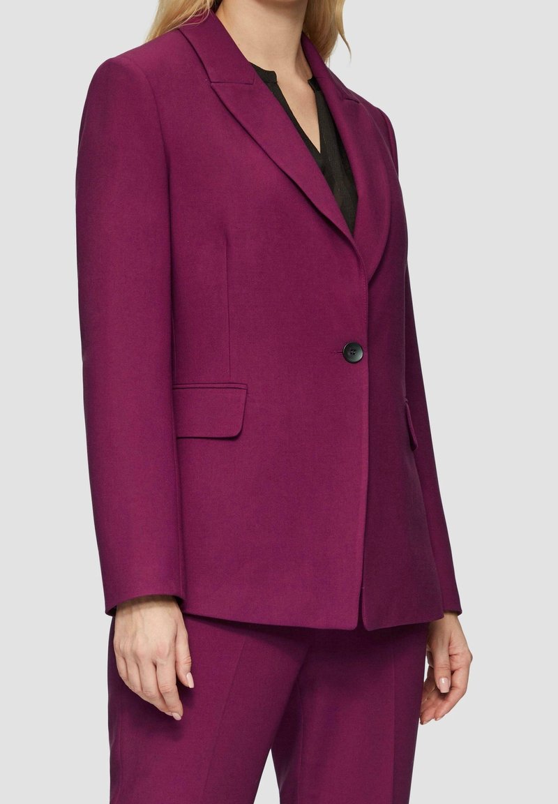 Magenta skräddarsydd kavaj med slagkrage, enkel knäppning och sidfickor. Tillverkad av ett mjukt tyg med en strukturerad passform.