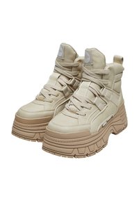 Sneaker alta beige con tomaia in pelle texturizzata, occhielli rinforzati, lacci piatti e suole in gomma spesse e scanalate per una migliore aderenza.