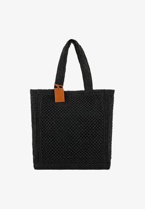 Tote bag nera intrecciata con manici robusti, forma rettangolare, superficie texture e un'etichetta in pelle color tan come accento. Ideale per l'uso quotidiano.