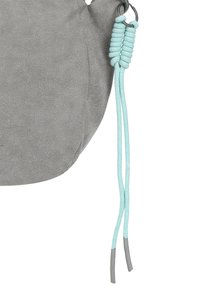 Graue Wildledertasche mit runder Form, ausgestattet mit mintfarbenen Seilakzenten und Metallbeschlägen. Strukturierte Oberfläche mit dezentem Glanz.