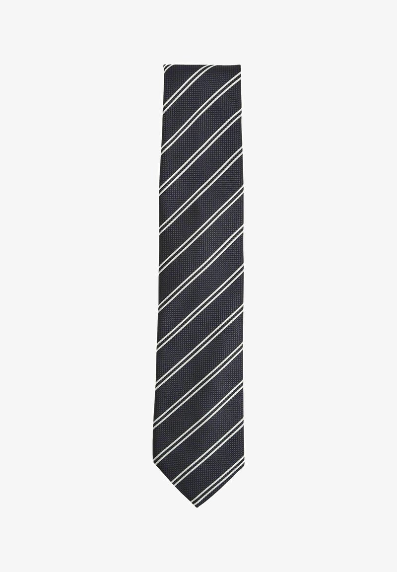 Cravatta blu navy con un motivo testurizzato, caratterizzata da strisce bianche diagonali. La cravatta è sottile, con una punta appuntita e una finitura liscia.