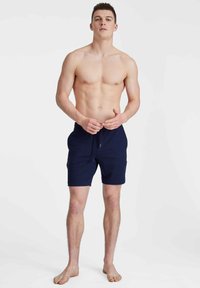 Shorts de bain navy avec taille élastique et cordon de serrage. Le tissu est lisse avec une coupe décontractée, comprenant des poches latérales et une longueur mi-cuisse.