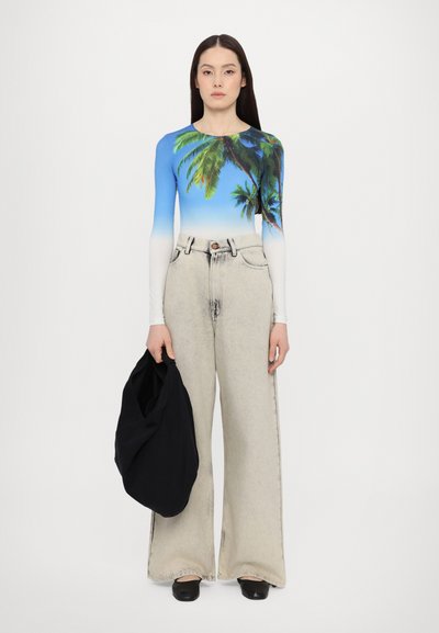 Long-sleeve bodysuit with a blue gradient and palm tree print, paired with high-waisted, light grey wide-leg jeans and holding a black bag.