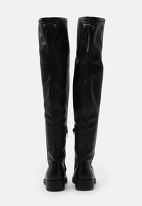 Black leather over-the-knee boots with a smooth texture, featuring laces at the top, zippers on the sides, and a sturdy, low heel.