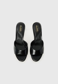 Svarta lädersandaler med öppet tåparti och en bred rem över ovandelen. Guld-logotyp på in sommar.
