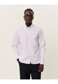 Ljusrosa långärmad skjorta med knappar i bomull, med en krage och en enkel bröstficka. Slät textur med en avslappnad passform.