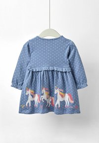 Sininen pilkullinen mekko, jossa on pitkät hihat, röyhelövyötärö ja pastellivärisiä brodeerattuja yksisarvisia helmassa. Puuvillamateriaalista, rento muotoilu.