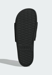 Black rubber sandal sole with a textured, diamond-pattern grip. Features embossed "adidas" logo. Smooth edges with a rounded toe design.