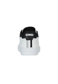 K-Swiss white sneaker with black textured heel, featuring a vertical grey and black stripe accent. Smooth synthetic material and cushioned sole.