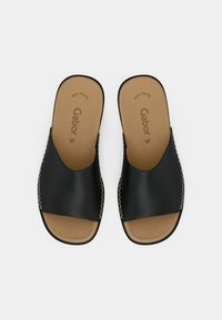 Černé skluzavkové sandály s hladkým koženým svrškem, kulatým otevřeným prstem, béžovou stélkou a dekorativním prošíváním podél okrajů. Velikost 37.