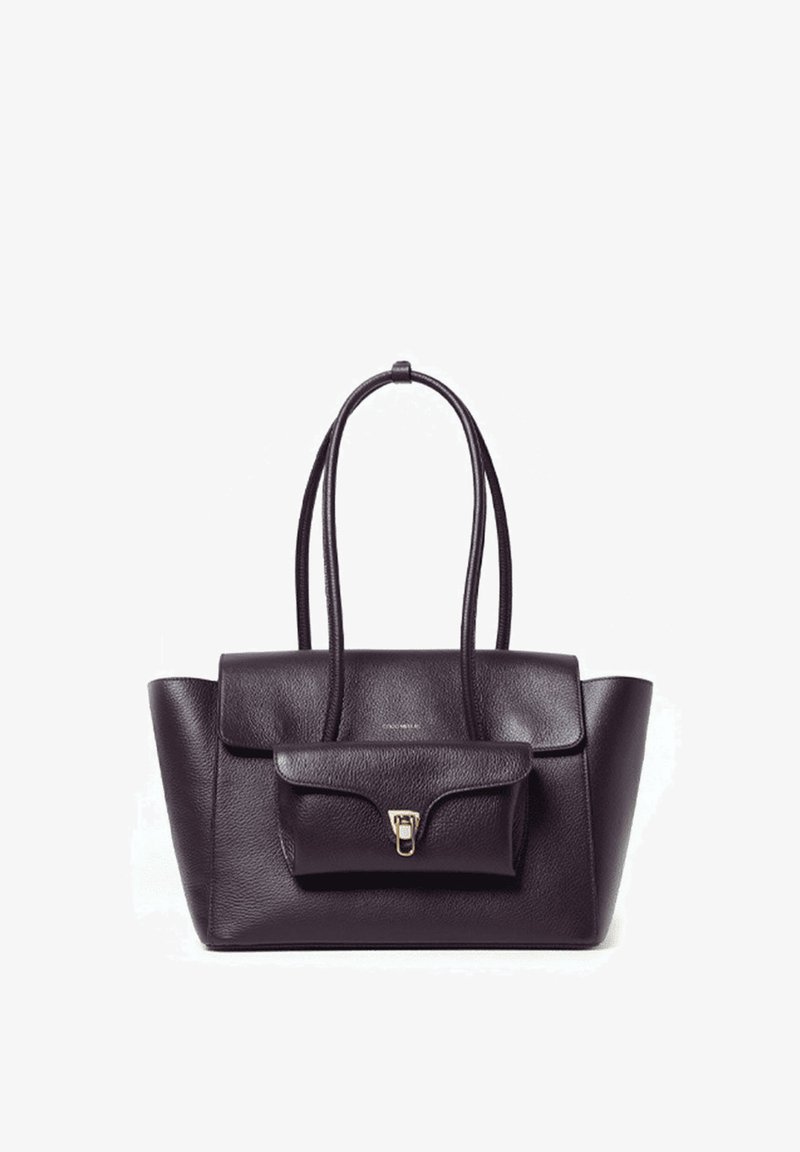 Sac à main en cuir violet foncé avec deux longues anses, design structuré, poche à rabat avant et détail de fermoir métallique.