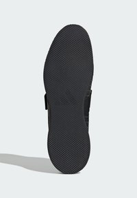 Czarna sportowa podeszwa buta z teksturowanej gumy, z wzorzystym bieżnikiem dla lepszej przyczepności oraz bocznymi elastycznymi paskami dla ciasnego dopasowania.